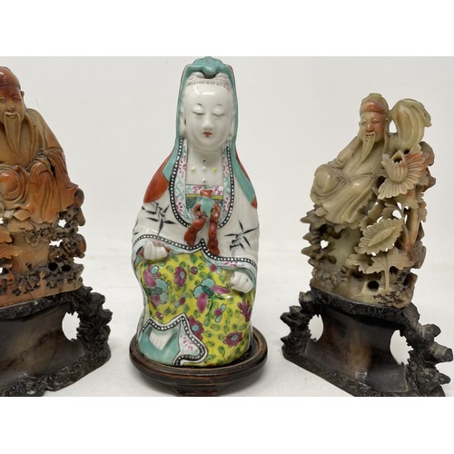 1559 - A Chinese figure of Guanyin, 23 cm high, and two carved soapstone figures (3)