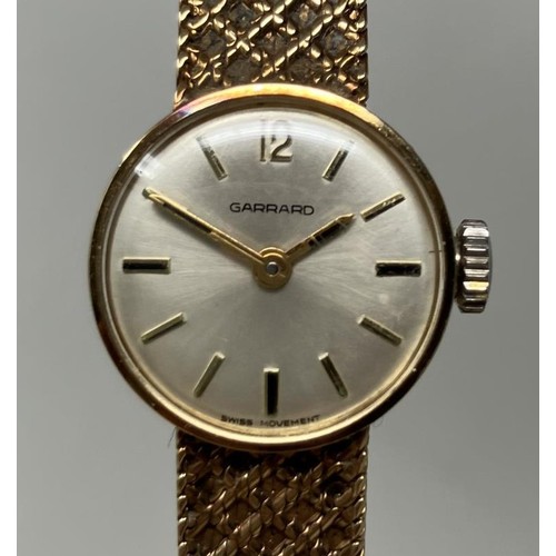 142 - A ladies 9ct gold Garrard wirstwatch, on a 9ct gold strap, with a Garrard box