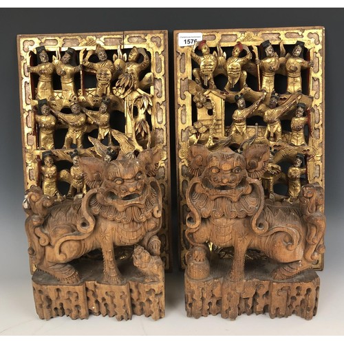 1576 - A pair of Chinese carved panels, decorated figures, highlighted in gilt, 40 x 25 cm, and a pair of c... 