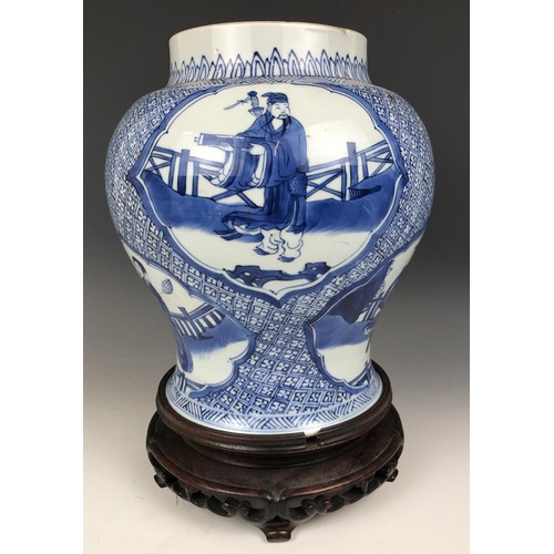 1569 - A Chinese blue and white vase, decorated figures, 20 cm high, on a carved wood stand