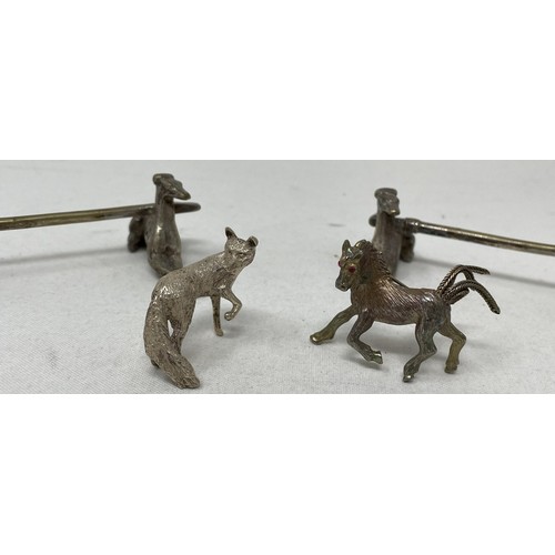 718 - A pair of novelty silver plated knife rests, in the form of greyhounds, a brooch in the form of a ho... 