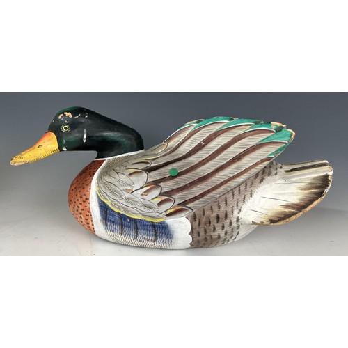 682 - A pottery figure of a duck, 30 cm wide, and a carved and painted figure of a duck, 51 cm wide (2)