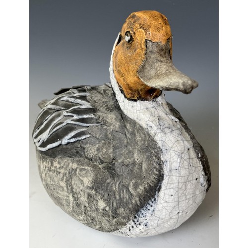 682 - A pottery figure of a duck, 30 cm wide, and a carved and painted figure of a duck, 51 cm wide (2)