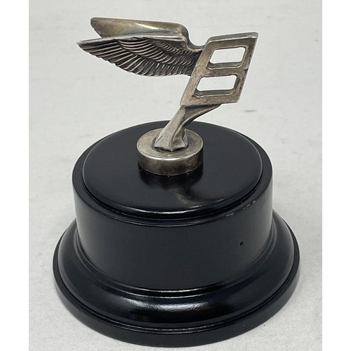 272 - An unusual Bentley long service presentation mascot, formed as a miniature B mascot, mounted on wood... 