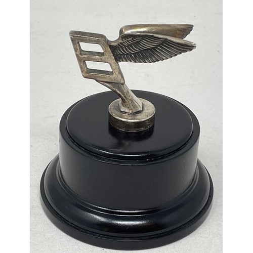 272 - An unusual Bentley long service presentation mascot, formed as a miniature B mascot, mounted on wood... 