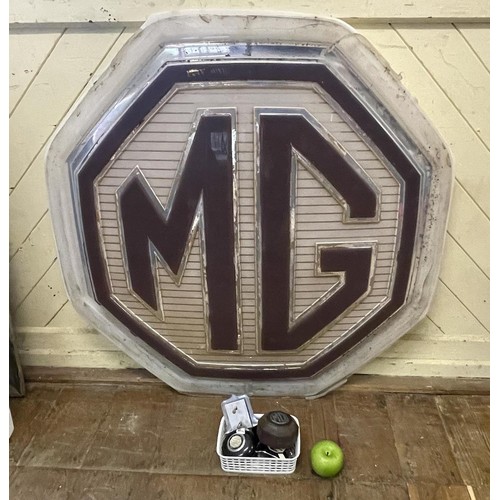 462 - An MG showroom sign, 95 cm wide, and an associated metal frame, 120 cm wide, an MG car badge and oth... 