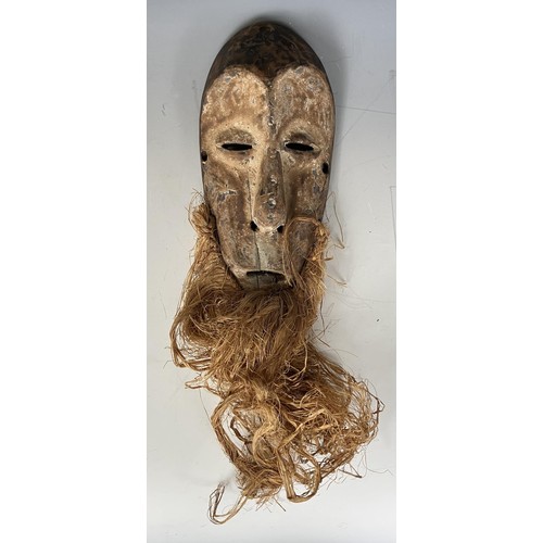 1825 - An African Lega type tribal mask, with a straw beard, 38 cm high