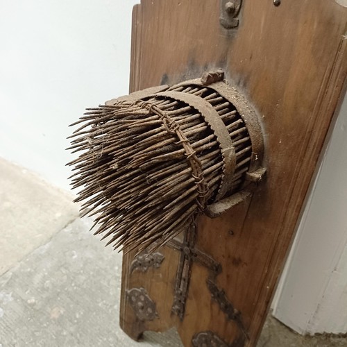 1904 - A wall mounted wooden plaque with metal spikes, 100 cm