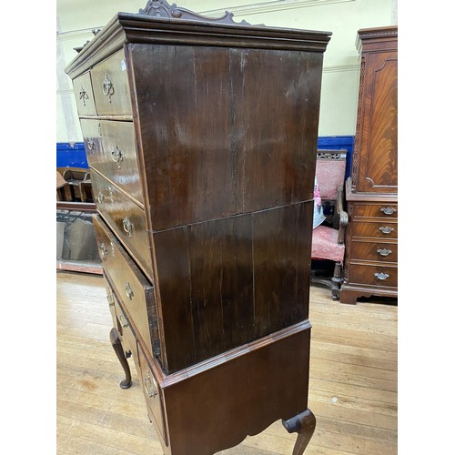 1962 - A walnut tallboy, the top having two short and three long drawers, the base with three drawers, on c... 