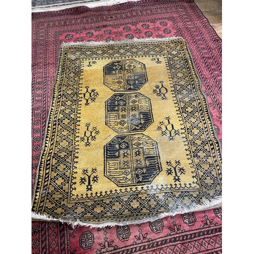 2006 - A red ground Afghan type carpet, 290 x 203 cm, a yellow ground rug, 175 x 130 cm and a red ground ru... 