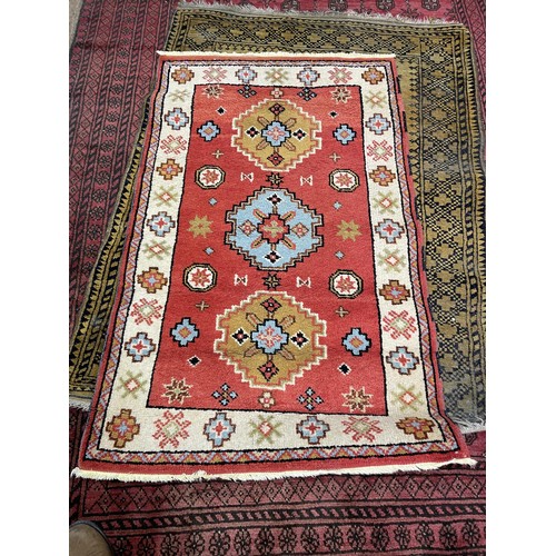 2006 - A red ground Afghan type carpet, 290 x 203 cm, a yellow ground rug, 175 x 130 cm and a red ground ru... 