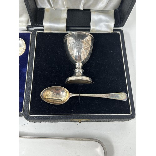 9 - A fiddle pattern spoon, another, a napkin ring, a pair of sugar tongs, an egg cup and spoon, cased, ... 