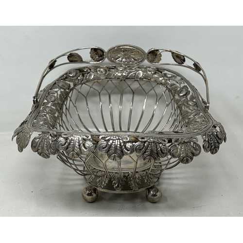 25 - A silver coloured metal pierced swing handled basket