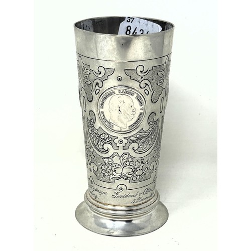 32 - A Continental silver coloured metal beaker, inset with coins, .800