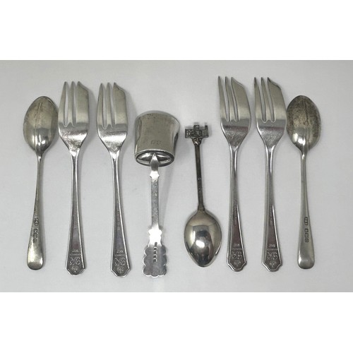 110 - A Continental silver coloured metal sugar scoop, a set of four silver plated cake forks, two silver ... 