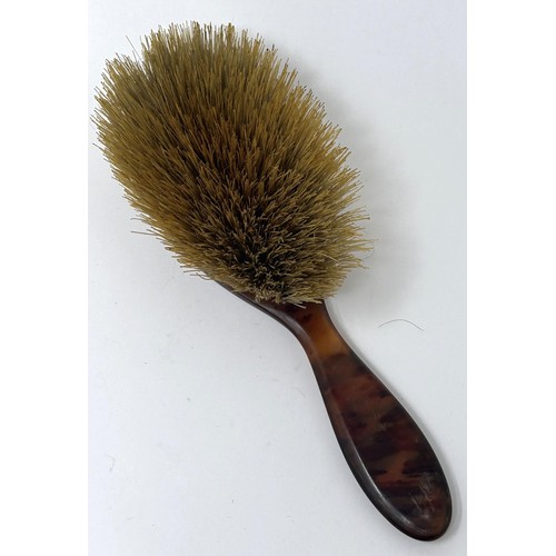 112 - An early 20th century tortoiseshell and yellow coloured metal hairbrush