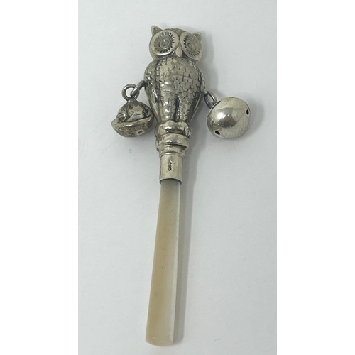 126 - A novelty silver coloured metal and mother of pearl baby's rattle, in the form of an owl