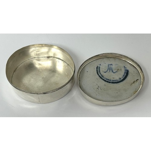 185 - A Continental silver coloured metal oval box, top inset with blue and white ceramic panel