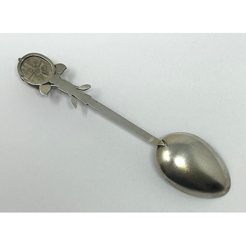 103 - A silver coloured metal and enamel teaspoon, decorated in the Egyptian manner, the finial inlaid wit... 