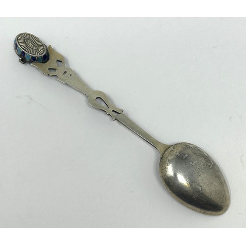 102 - A silver coloured metal and enamel spoon, decorated ancient Egyptian symbols, the finial containing ... 