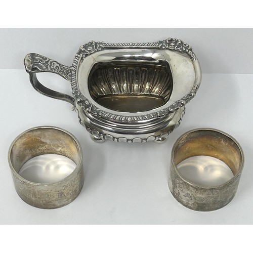 123 - A George V silver cream jug, and two silver napkin rings, various dates and marks, 9.3 ozt (3)