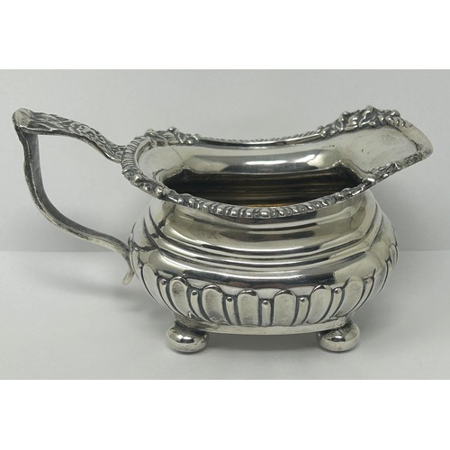 123 - A George V silver cream jug, and two silver napkin rings, various dates and marks, 9.3 ozt (3)