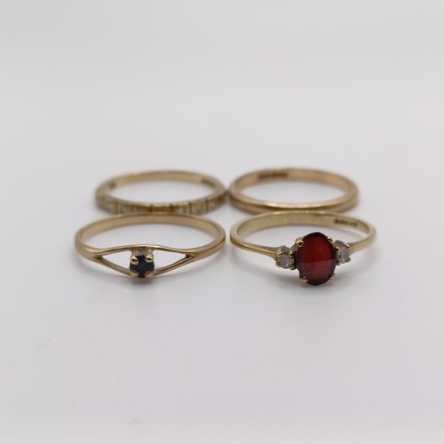 416 - A 9ct gold, red stone and diamond ring (size M), a half eternity ring (size M 1/2), a wedding band (... 