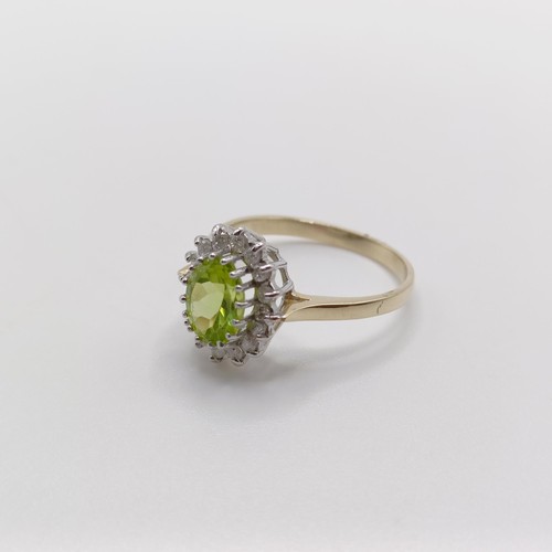 421 - A 9ct yellow and white gold cluster ring, set with an oval-cut peridot and RBC diamonds, size N 1/2