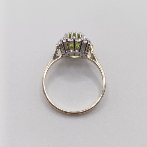 421 - A 9ct yellow and white gold cluster ring, set with an oval-cut peridot and RBC diamonds, size N 1/2