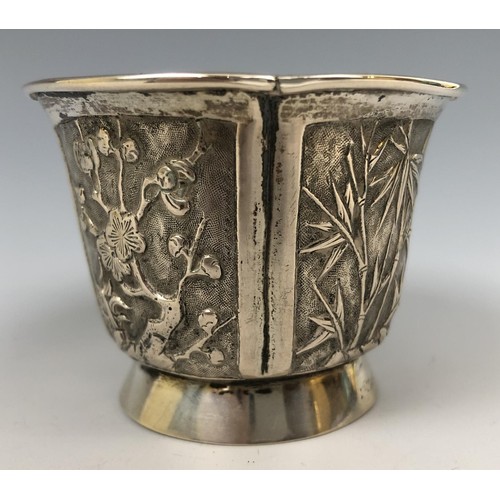 294 - A Chinese silver coloured metal beaker, embossed flowers and foliage, 5.5 cm high