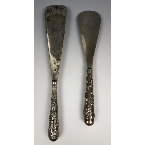 295 - A Chinese silver coloured metal shoe horn, the handle decorated a dragon chasing a flaming pearl, 24... 