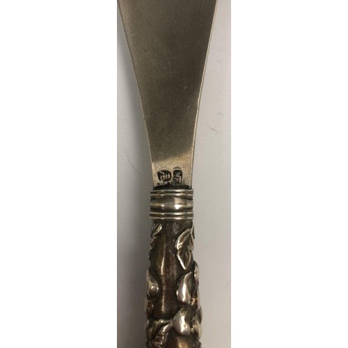 295 - A Chinese silver coloured metal shoe horn, the handle decorated a dragon chasing a flaming pearl, 24... 