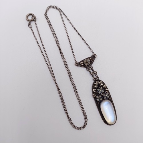 407 - An Arts and Crafts silver coloured metal and moonstone pendant, on a chain, by Jean Bassett Provenan... 