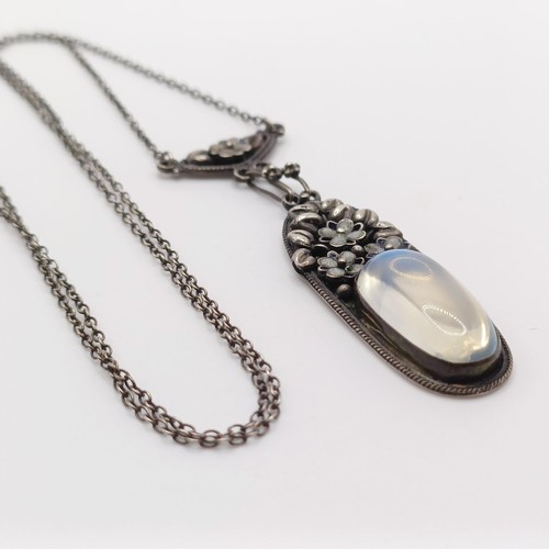 407 - An Arts and Crafts silver coloured metal and moonstone pendant, on a chain, by Jean Bassett Provenan... 