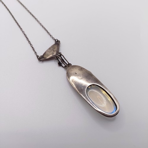 407 - An Arts and Crafts silver coloured metal and moonstone pendant, on a chain, by Jean Bassett Provenan... 