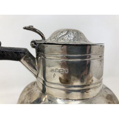 203 - A Victorian silver hot water jug, with an ebonised handle