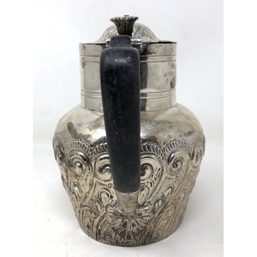 203 - A Victorian silver hot water jug, with an ebonised handle