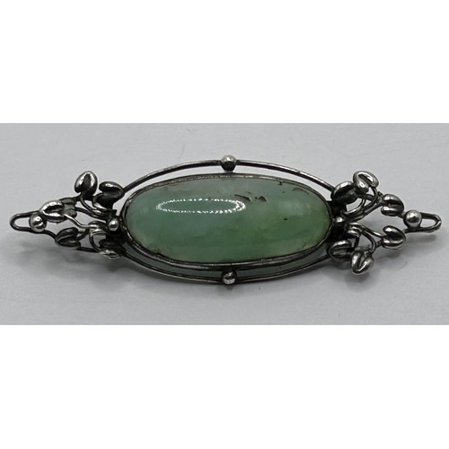 401 - An Arts and Crafts silver coloured metal and green stone brooch by Jean Bassett Provenance:  Descent... 