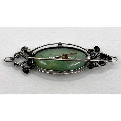 401 - An Arts and Crafts silver coloured metal and green stone brooch by Jean Bassett Provenance:  Descent... 