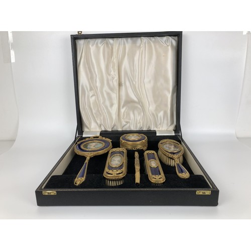 264 - An impressive early 20th century gilt metal and blue enamel dressing table set, inset with portrait ... 