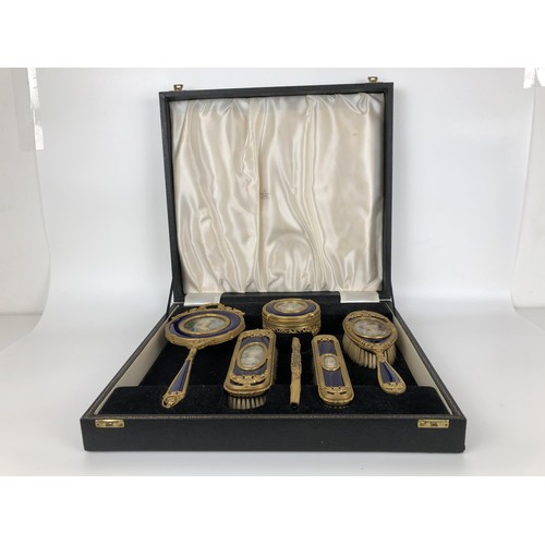 264 - An impressive early 20th century gilt metal and blue enamel dressing table set, inset with portrait ... 