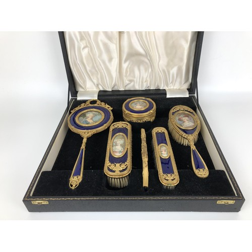 264 - An impressive early 20th century gilt metal and blue enamel dressing table set, inset with portrait ... 