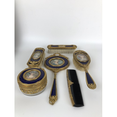 264 - An impressive early 20th century gilt metal and blue enamel dressing table set, inset with portrait ... 