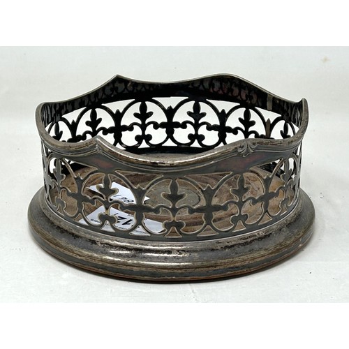 312 - A silver coloured metal pierced bowl, and a silver plated bottle coaster (2)