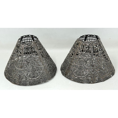 317 - A pair of Continental silver coloured metal pierced lampshades, 16 cm diameter