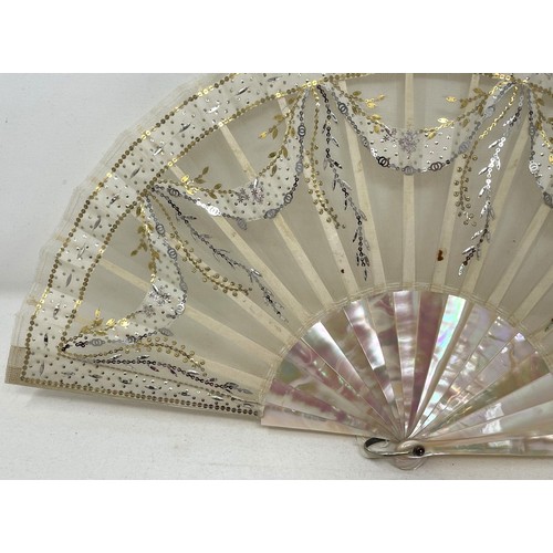 814 - A mother of pearl fan, the lace applied paper festoons, 24 cm