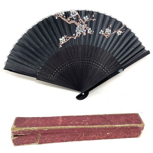 820 - An ebonised fan, the silk painted flowers, 25 cm, boxed, and five other fans (6)