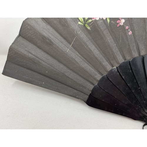 820 - An ebonised fan, the silk painted flowers, 25 cm, boxed, and five other fans (6)