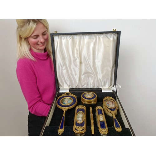 264 - An impressive early 20th century gilt metal and blue enamel dressing table set, inset with portrait ... 