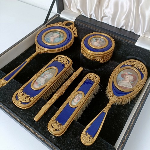 264 - An impressive early 20th century gilt metal and blue enamel dressing table set, inset with portrait ... 